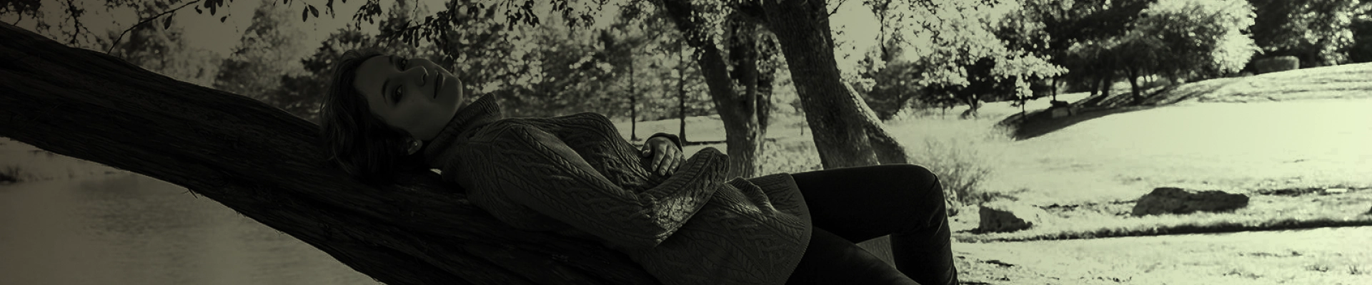closeup photo of a woman lying in a tree